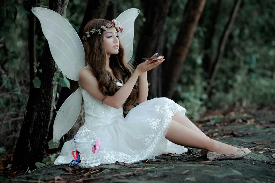 A woman dressed as a fairy and wearing appropriate makeup.