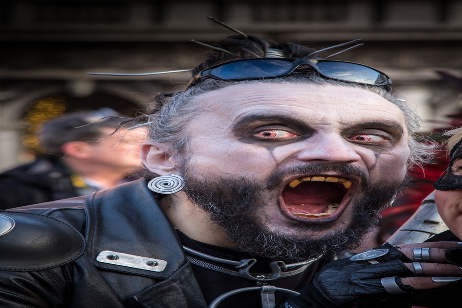 A man implementing a classic Halloween makeup idea - vampire makeup.